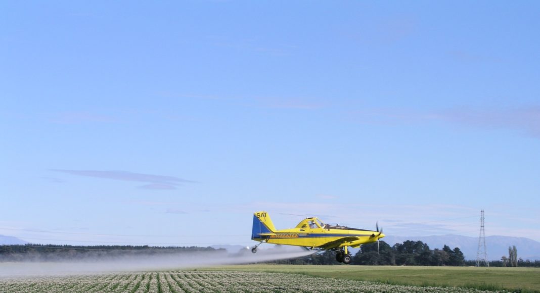 Plane spraying potato field